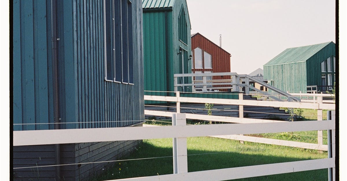Vibrant wooden barns with lush green grass in rural Dvoryaninovo, Russia.