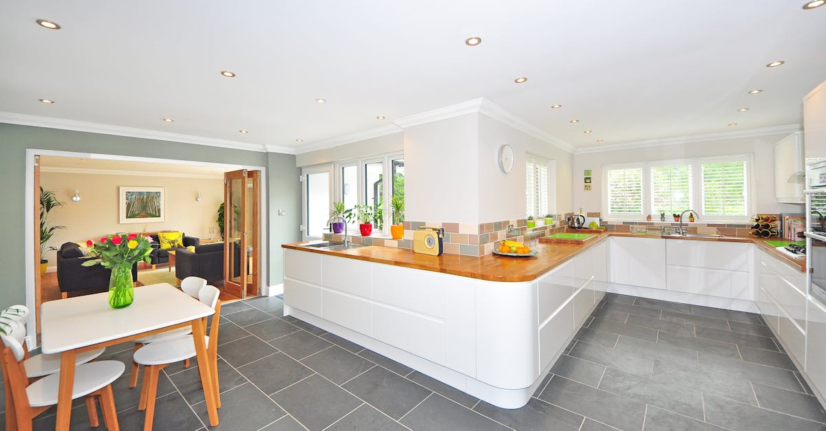 A spacious modern kitchen with elegant interiors featuring a dining table and luxurious design.