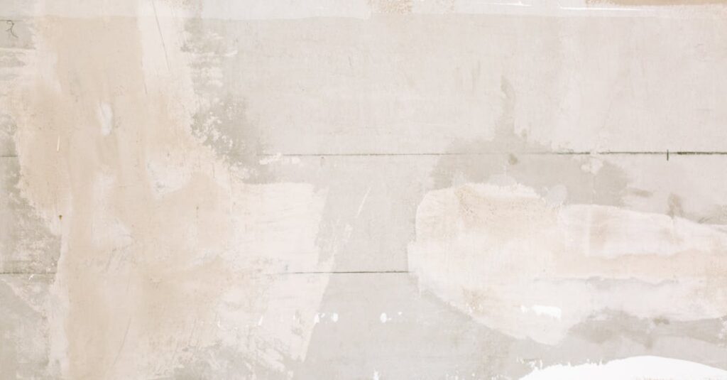 Close-up of an unfinished wall showing plaster and paint textures in a home renovation.